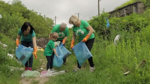 Team of Nature Activists in Eco T-shirts Picking Up Plastic Trash in Park. Recycle, Earth Pollution
