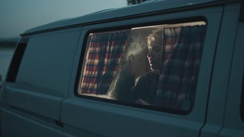 Woman Looks Out Van Window at Night