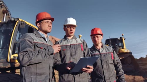 Construction Workers Discuss Plans at Construction Site