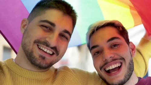 Smiling Couple Holding Rainbow Flag in City