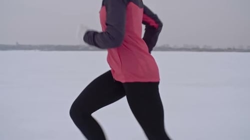Woman Runs in Winter Landscape, Side View