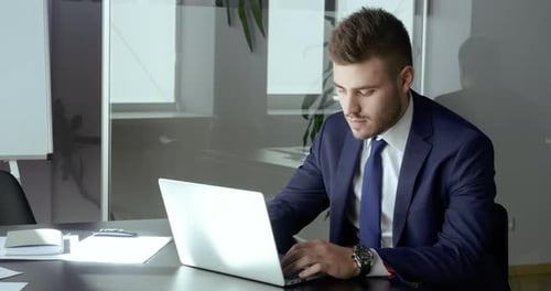 Stylish Young Adult Working on Laptop in Office