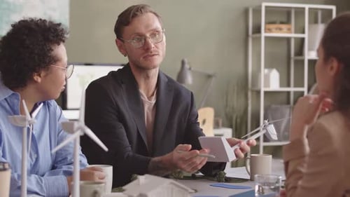 Team Discussing Wind Turbine Model in Office