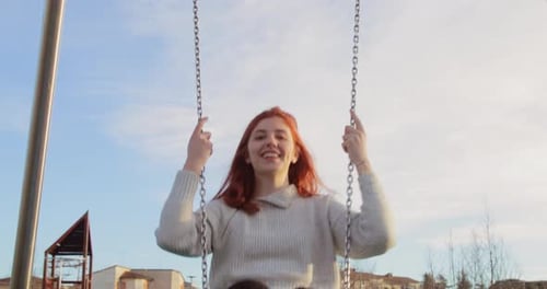 Belle jeune fille s'amuse dans un parc avec la balançoire dans la nature