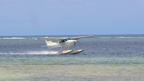 Weißes Meeresflugzeug landet in einer ruhigen Lagune