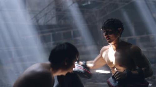 4K Asian man boxer do practicing boxing with male coach in abandoned building.