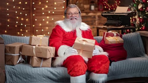 Santa Claus Holding Christmas Gift on Sofa