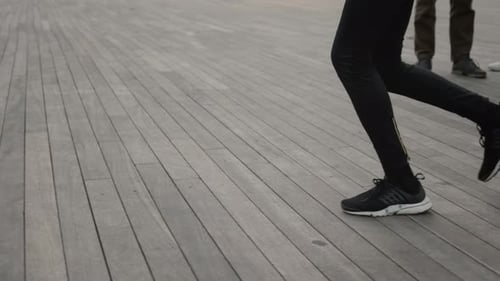 Female Legs in Sport Leggings and Sneakers Running on Street