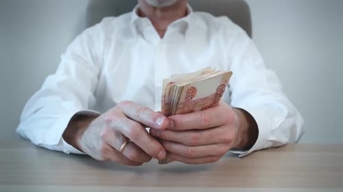 Man Counting Stack of 5000 Currency Bills