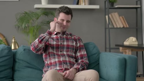 Man Having Headache While Sitting on Sofa