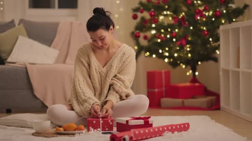 Woman Wrapping a Christmas Gift at Home
