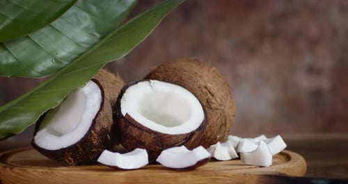 Fresh Coconut Halves and Chunks on Wood