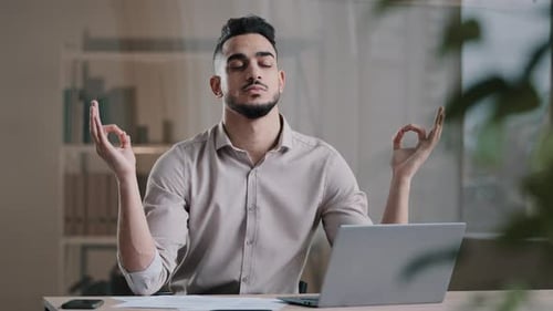 Bearded Man Meditating at Office Desk