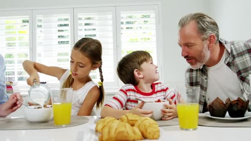 Family Enjoys Breakfast Together at Kitchen Table