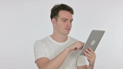 Young Adult Using Tablet Against White Backdrop
