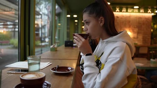 Beautiful Young Woman with a Cup of Tea at a Cafe