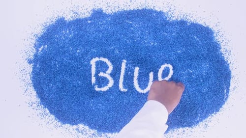 Hand Writing Blue Word in White Powder