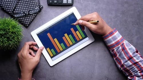Man's Hand Working on Digital Tablet at Office Desk, Using Self Created Chart