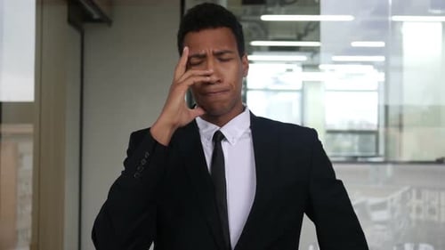 Stressed Businessman with Headache in Modern Office
