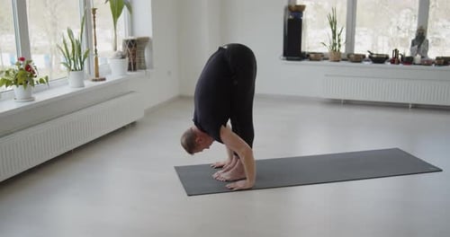 Man Performing Yoga Routine in Bright Studio