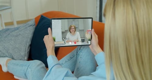 Woman Lying on Couch Having an Online Lesson