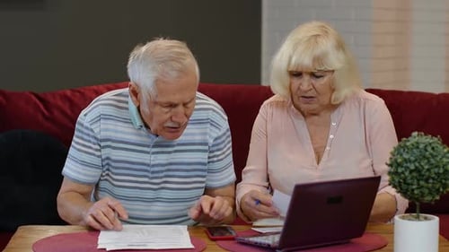 Senior Couple Checking Calculating Bills Bank Loan Payment Doing Paperwork Discuss Unpaid Debt Taxes