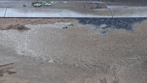 A Through a Large Puddle Flooding the Road During Thunderstorm