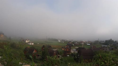 Serene Village Landscape Shrouded in Morning Fog