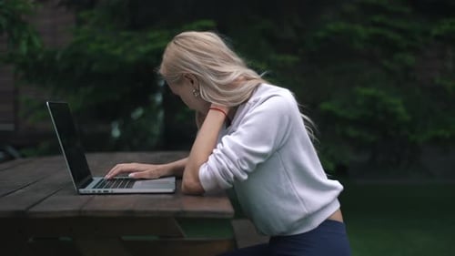 Woman working on laptop in garden