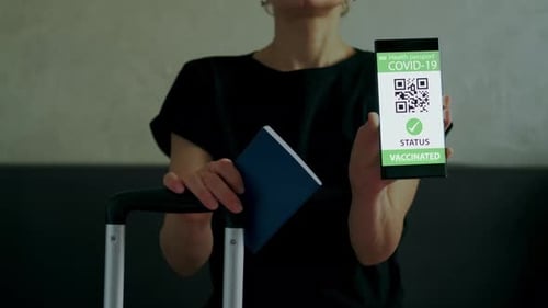 Woman Holds Health Passport and Mobile Phone