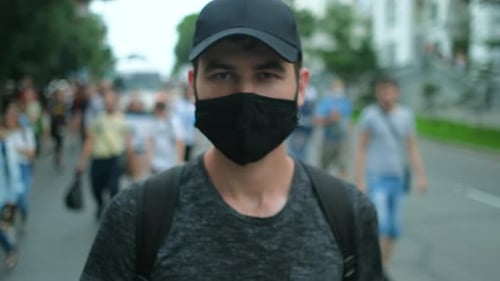 Young Adult Wearing Mask Walking in City Crowd