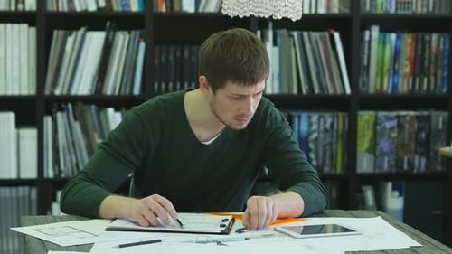 Young Capable Architectural Engineer Working Late Hours in His Office