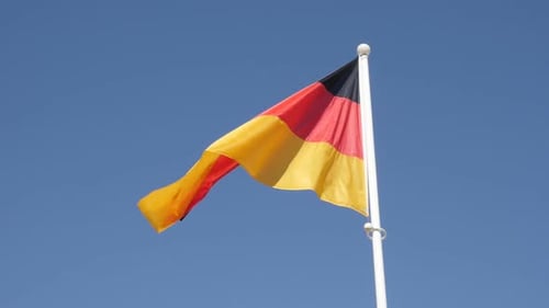 German Flag Waving Proudly Against Blue Sky