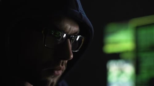 Homem estranho olhando atentamente para a tela do monitor, envolvido em hackers de servidores