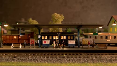 Locomotiva a diesel de brinquedo em movimento pela estação ferroviária modelo.