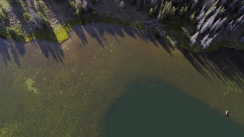 Looking down at lake in forest viewing boat below