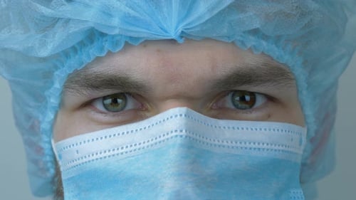 Portrait d'un jeune scientifique de sexe masculin portant un équipement médical de protection. Les yeux du docteur regardent directement vers la caméra