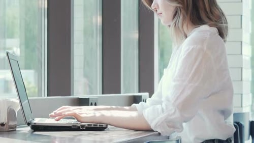 Sliding Shot of a Woman Working on Laptop at the Coffee Shop