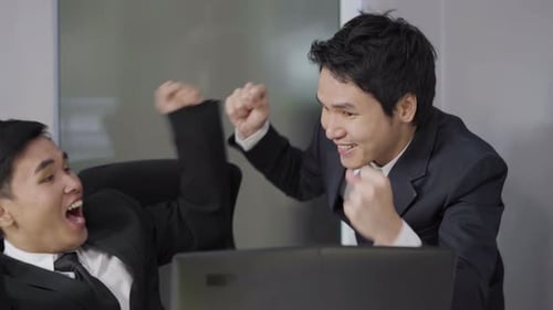 Businessmen Celebrate Success in Modern Office