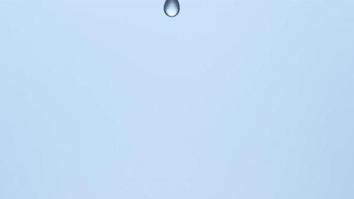 Water Droplet Creating Ripples on Blue Surface