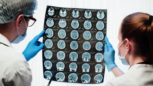 Two Doctors Reviewing a CT Scan of a Brain