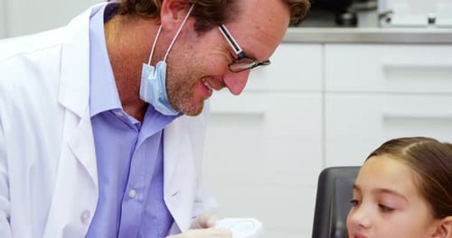 Dentist Explaining Teeth Model to Child Patient