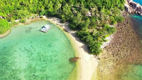 Beautiful hidden bay on cape of tropical island with lush vegetation and sandy beach, rocky coastlin