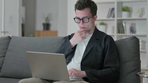 Young Adult Working on Laptop at Home