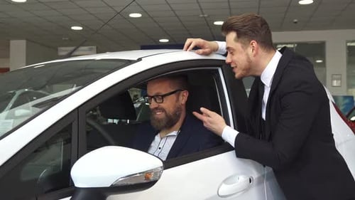 Salesman and Customer Discuss Car Purchase in Dealership