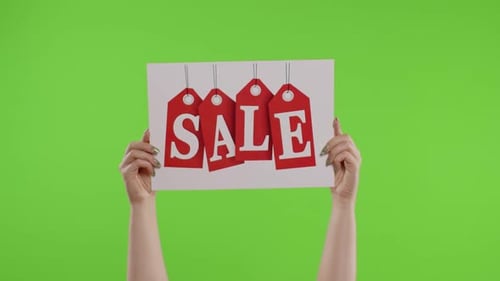 Sale Word Advertisement Inscription on Paper Sheet in Womans Hands on Chroma Key. Slow Motion