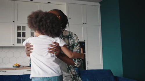 Happy African American Father Playing with His Little Daughter Catching Her and Swinging Around