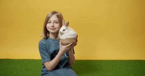 Girl Holds White Rabbit in Basket Smiling