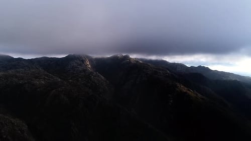 Fliege durch die Wolken über die Berggipfel