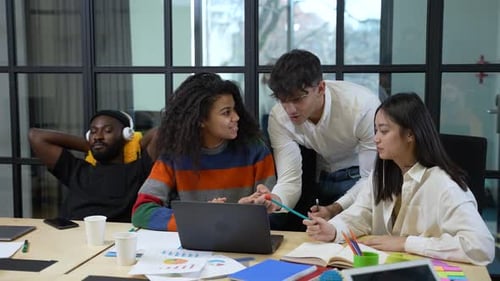 Des collègues positifs discutent d'un projet sur un ordinateur portable